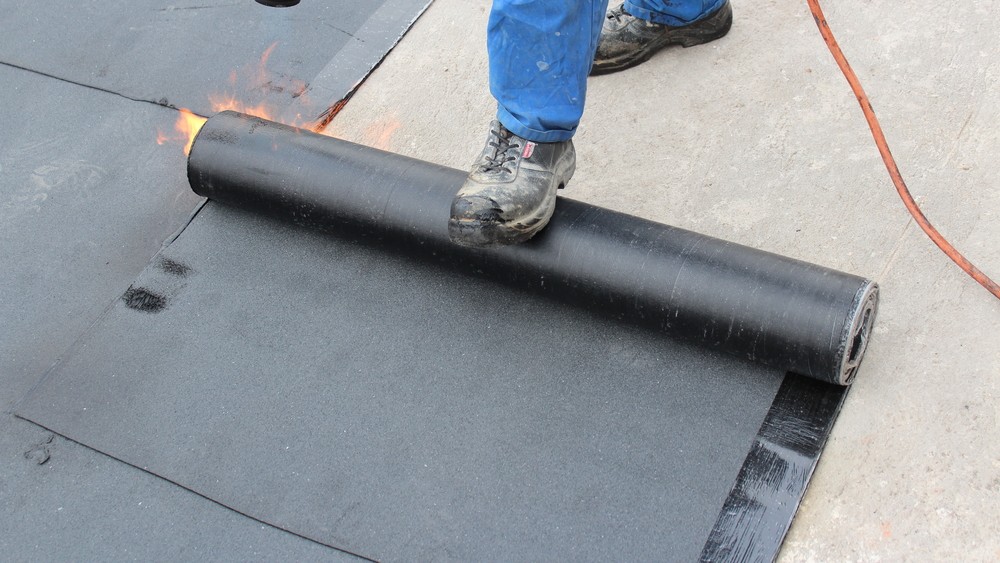 rolling out roofing materials