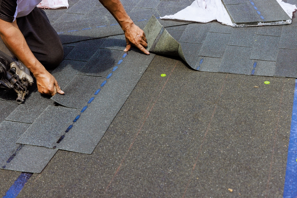 asphalt shingles being installed by worker