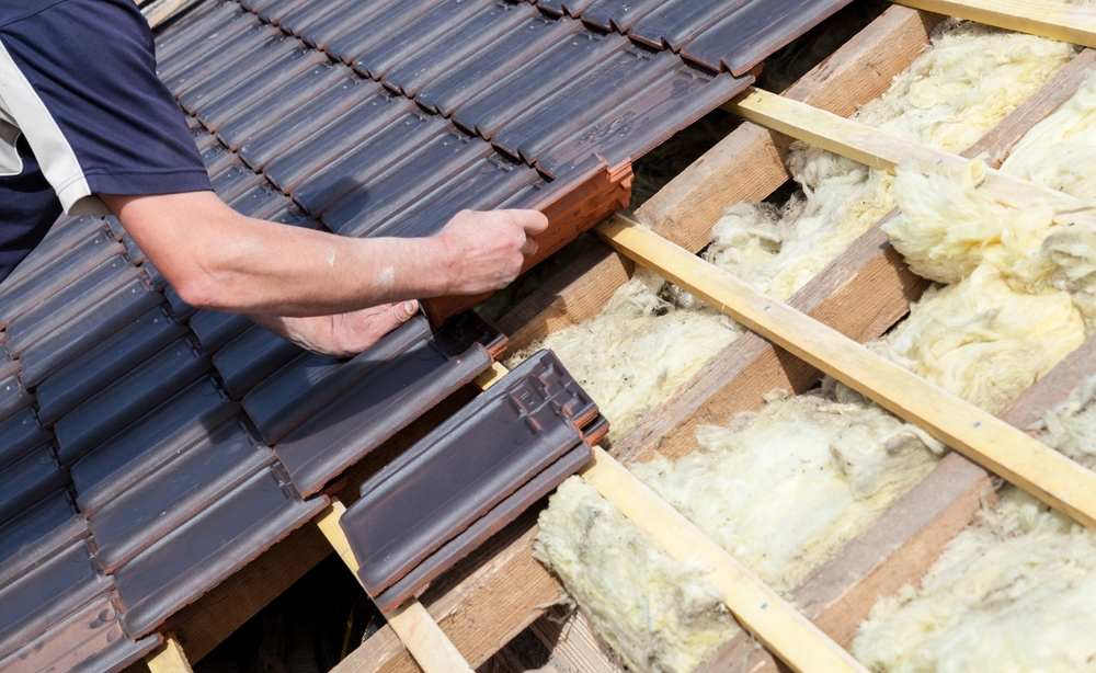 roofer laying tile on a roof