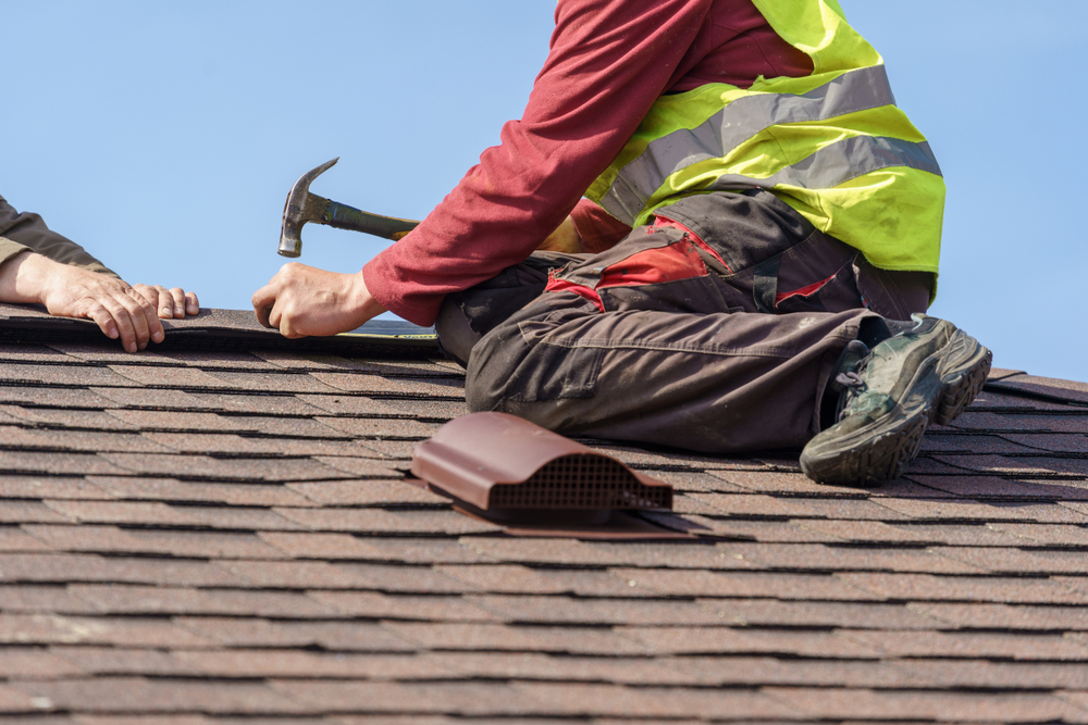 worker hammering down a roof